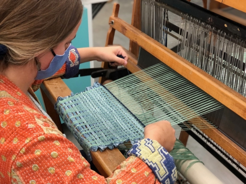 Photograph of a loom with a multicolor experimental weaving in progress.
